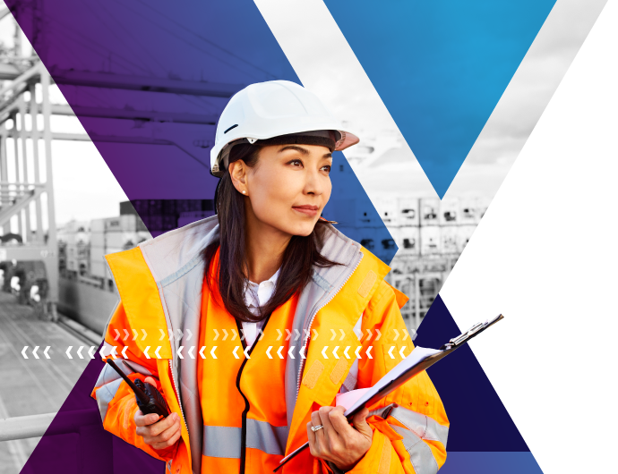 A female longshoreman in hardhat and safety vest manages loading of cargo containers.